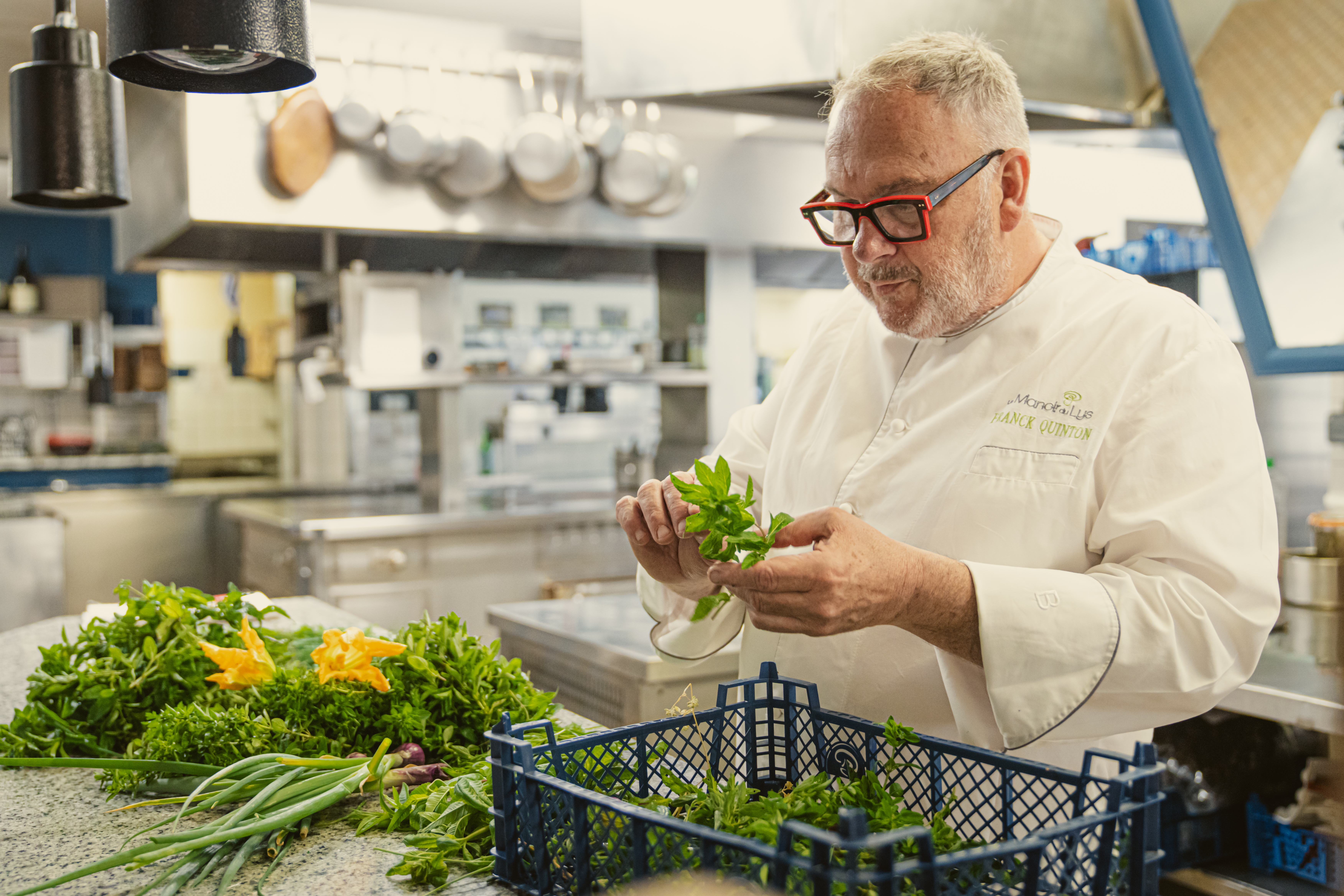 Le Chef Franck Quinton en cuisine au Manoir du Lys, travaillant les herbes et légumes du potager avant le service.