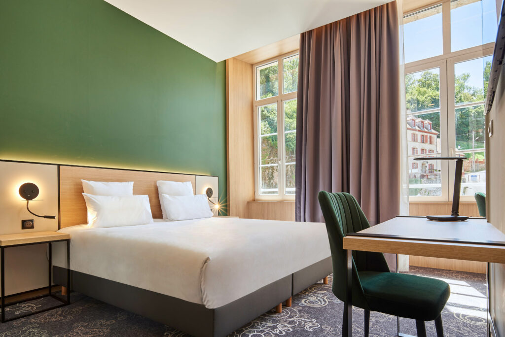 Confort et luminosité dans les chambres du Grand Hôtel Évaux-les-Bains, entre nature et histoire.