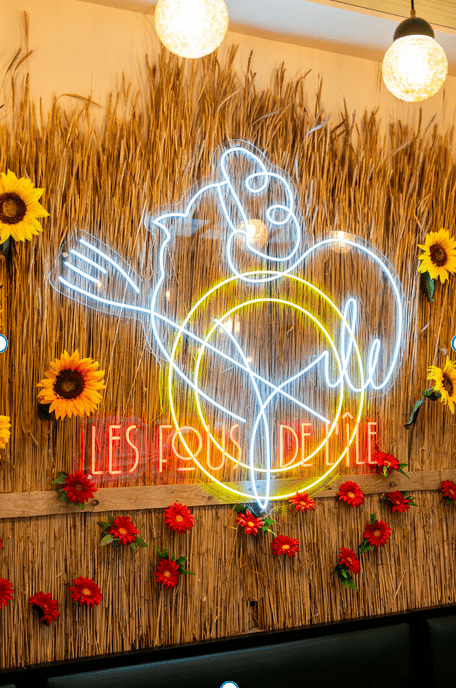 Element de décoration du restaurant : néon bleu représentant une poule avec une tocque tenant une fourchette.