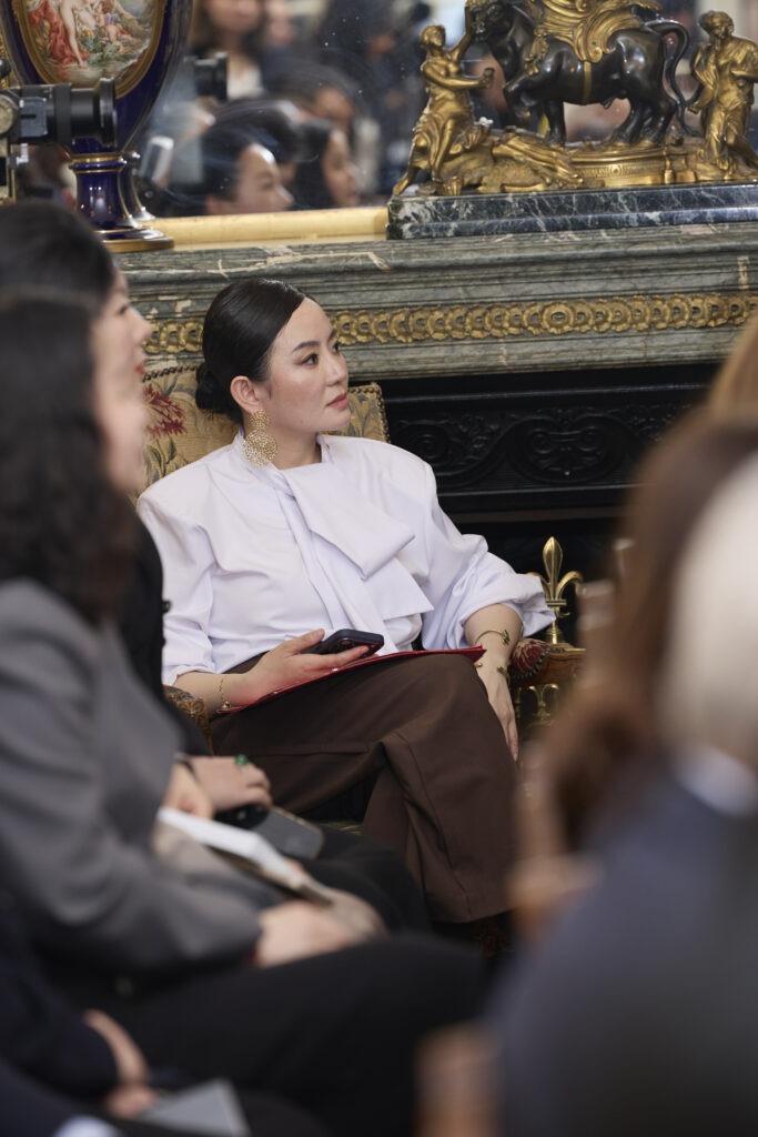 Femme chinoise assise, tournée de profil. Listen to Her Parole 2026