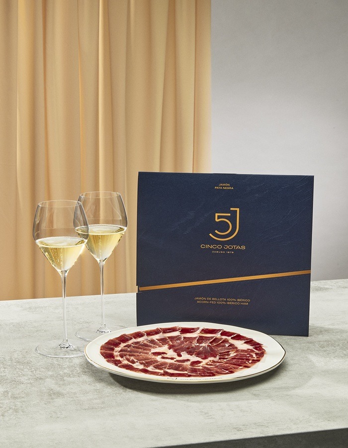 Vue d'une assiette de jambo, menu Cinco Jotas, deux verres de vin blanc